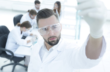 Fototapeta premium image is blurred. young scientist holding tube with the reagents