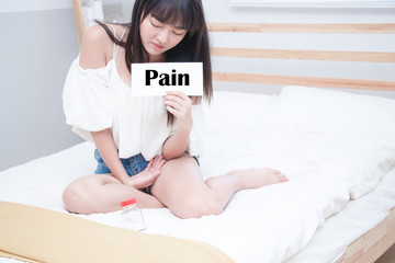 Young female suffering form abdominal pain. Causes of abdominal pain include dysmenorrhea,...