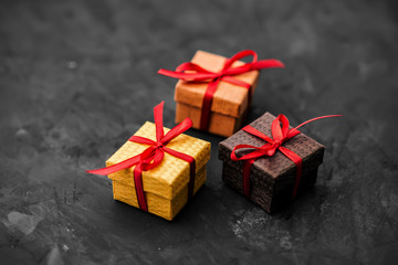 Three small gift boxes on dark background.