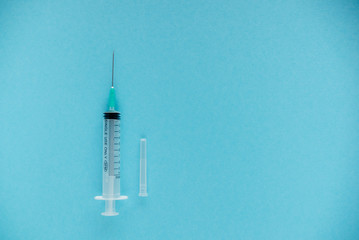 Transparent syringe with a needle, on a background. No liquid in the syringe. Single use only.