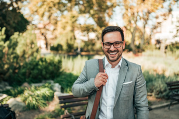 Portrait of a modern business man outdoors. Smiling and looking at camera.