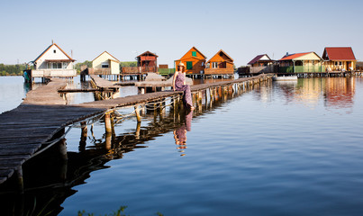 Obraz premium woman walking on the planks at floating village on lake Bokod, Hungary
