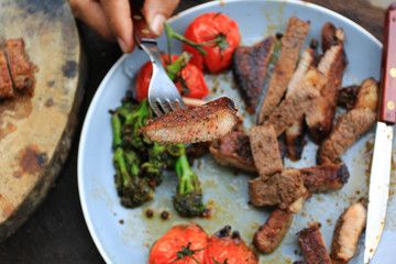 Slices of beef steak and roast vegetables on meat fork in the bowl, food meat or barbecue