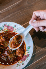 Thai food on dinner table, pork belly curry - Moo Cha Muang in vintage bowl