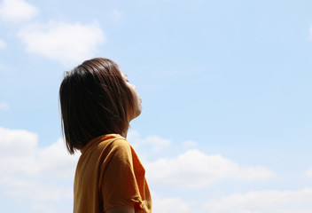 asian woman closed her eyes relax with blue sky in the park.