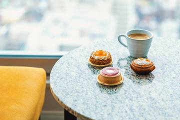 Handcrafted gourmet fruit tarts and pastries with coffee in a room high above the city