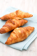 Tasty buttery croissants on old wooden table.