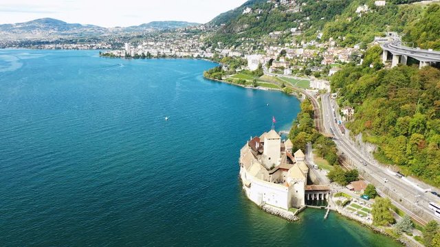 Aerial view of medieval island castle Chillon located in city of Montreux, resort town by Geneva Lake (Lac Leman) - landscape panorama of Switzerland from above, Europe