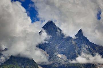Peak of the mountain with glaciers against the background of clouds and sky. Caucasian ridge,...