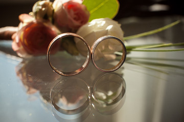 The reflection of two wedding rings in the glass