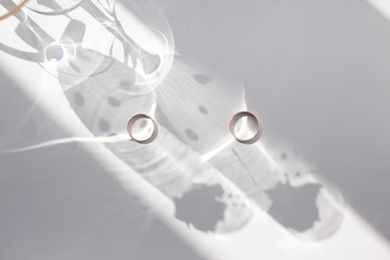 Golden wedding rings on a light background.