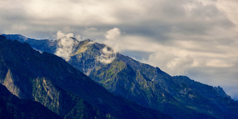 Clouds over the tops of the rocky mountains. Photographed in the Caucasus, Russia.