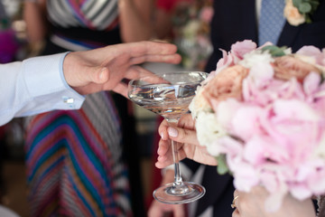 Man's hand reaches for a martini glass