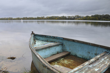 Naklejka premium Old boat on water tied to shore 