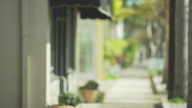 Defocused view down empty sidewalk with small office building 