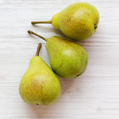 Fresh pears on a white wooden table, overhead view. Close-up.