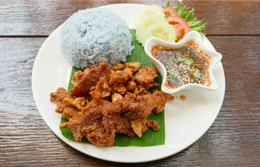Thai style food, fried pork with blue cooked rice and spicy dipping sauce.