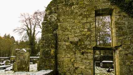 Ruin of an ivy covered chapel in a disused rural graveyard.
