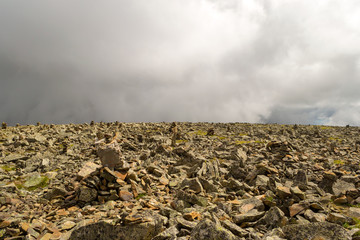 top of the Sarlyk mountain from the stones stacked on each other, balancing in the air, indicating the way for tourists and pilgrims where to go so as not to get lost in the Altai.