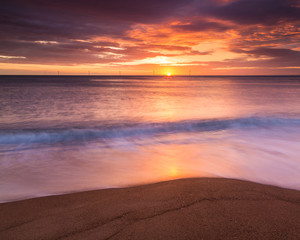 Fototapeta na wymiar Sunrise over Seaton Sluice Beach and Harbour entrance on the coast of Northumberland, England, UK.