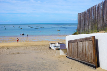Portail avec porte en bois et mur blanc ouvrant sur la mer