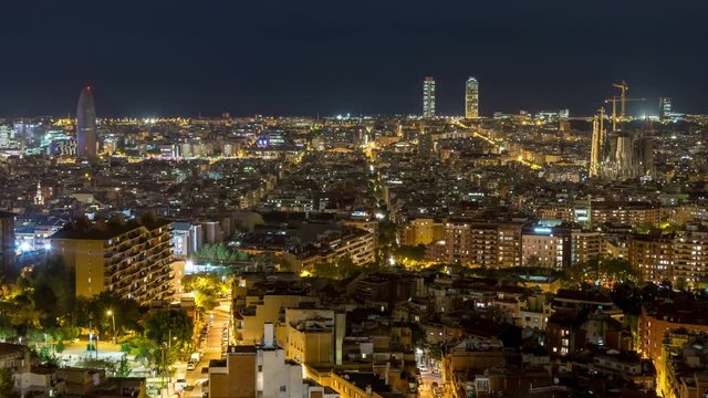 Barcelona city skyline. Panoramic view. Day to night time lapse video. City lights switch on.