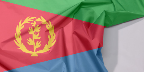 Eritrea fabric flag crepe and crease with white space, tricolor of green, red triangle on blue and green triangle with olive branch on gold color.