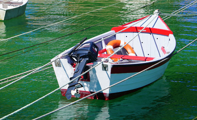 Barque à moteur blanche et rouge amarrée à des fils aériens tendus