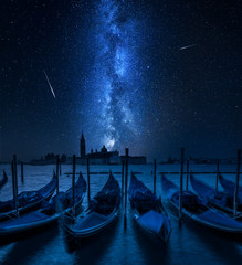 Swinging gondolas in Venice and milky way with falling stars