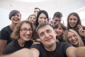 Self portrait of young project team in casual outfit shooting selfie on front camera with joyful...