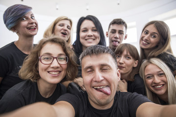 Self portrait of young project team in casual outfit shooting selfie on front camera with joyful cheerful expression having leisure, timeout. Startup