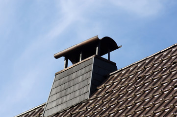 Schornstein mit Regenschutz auf dem Dach