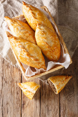 Pastry stuffed with minced meat and onion on rustic background. Karaite kibinai Lithuanian national dish close-up. Vertical top view