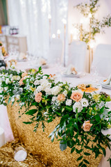 Wedding restaurant banquet decorations with flowers. Wedding arch andnewlyweds table with white...