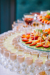 Candy bar with a lot of cookies and fruits during the wedding. chocolate fountain and wedding cake. Coktails and drink at the table