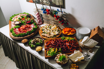 Buffet table of reception with burgers, cold snacks, meat, hum and salads. Tapas bar.
