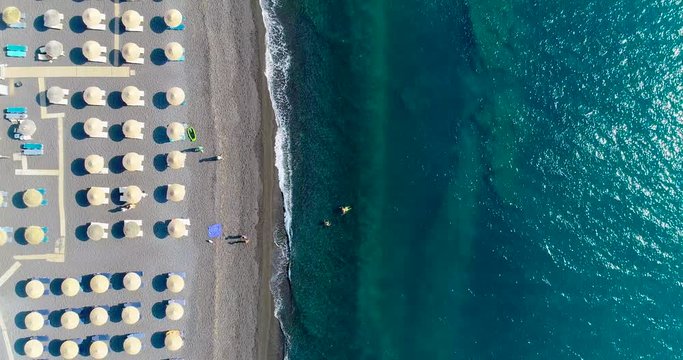  beach with umbrella on the island of Santorini in aerial view