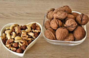walnuts whole and various peeled nuts, cashews, almonds and hazelnuts in a glass and porcelain cup