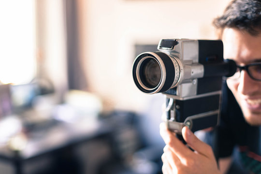 Junger Mann dreht mit Vintage/Retro-Kamera einen Film für ein Filmfestival 