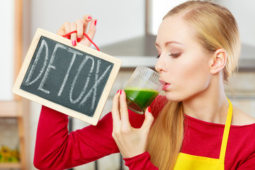Woman holding vegetable juice and detox sign