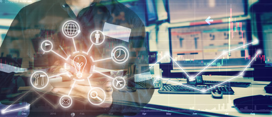 Double exposure of engineer man holding tablet for Stock market quotes and chart in monitor computer room with business office equipments .business and money trading concept