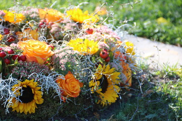Grabschmuck mit gelben Blumen nach Beerdigung auf dem Friedhof