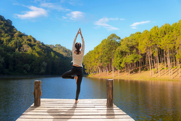 Fototapeta na wymiar Healthy woman lifestyle balanced practicing meditate and zen energy yoga on the bridge in morning the nature. Healthy life Concept..