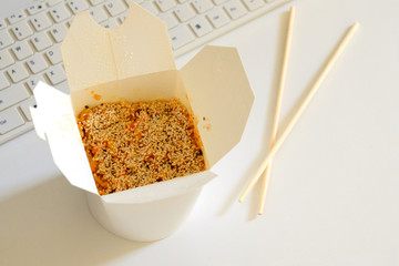 Opened chinese noodles on a white background. Sticks beside it.