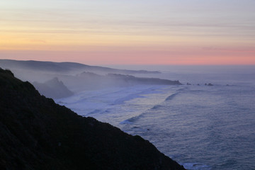 Fototapeta na wymiar Evening pink sunset over the ocean and rocky coastline of big sur