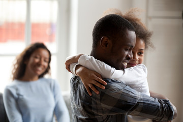 Black African happy family together at home. Close up loving American father strong embrace lovely...