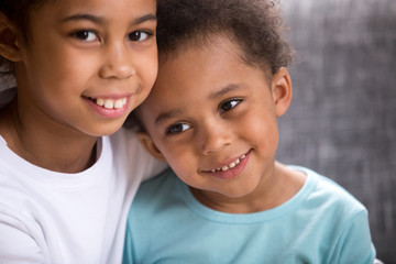 Close up portrait of beautiful adorable black African siblings toddler brother and preschool sister...