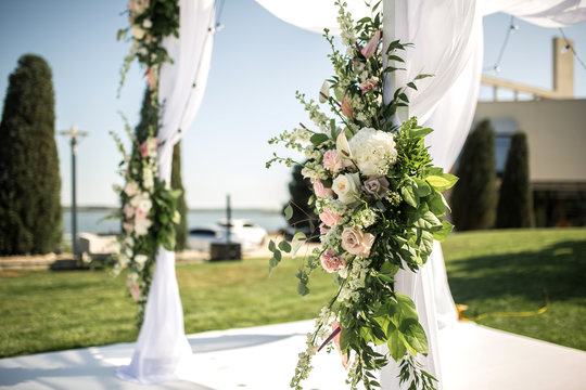 Outdoor wedding ceremony. Wedding chuppa decorated with fresh flowers