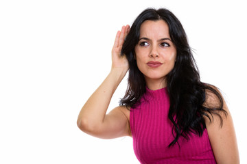 Studio shot of young beautiful Spanish woman listening