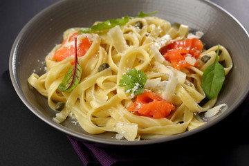 Homemade pasta with fish in bowl close-up